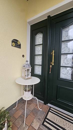 Grüne Haustür mit Willkommensbereich