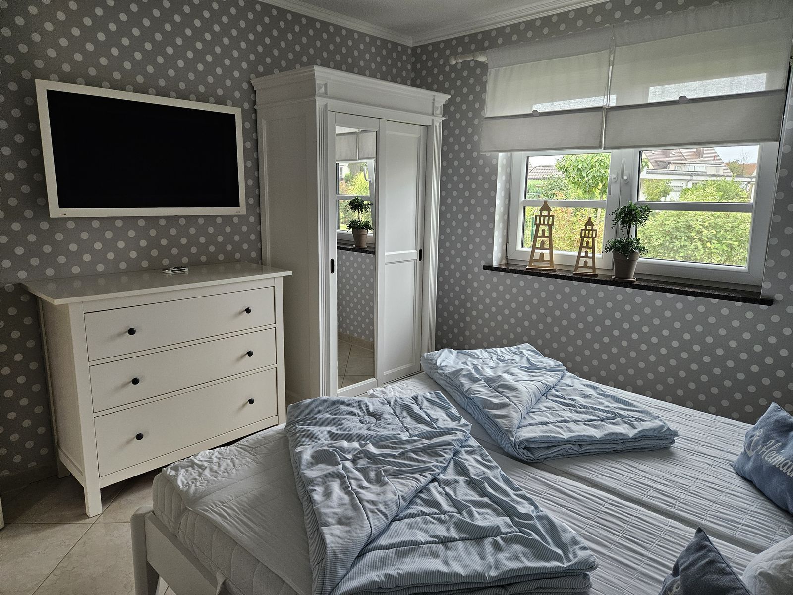 Schlafzimmer mit Doppelbett und Fernseher